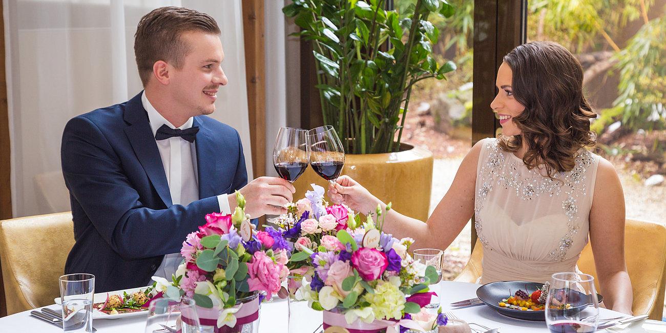 Pärchen stößt mit Rotwein bei der Hochzeit an