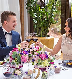 Pärchen stößt mit Rotwein bei der Hochzeit an