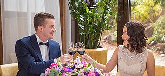 Pärchen stößt mit Rotwein bei der Hochzeit an 