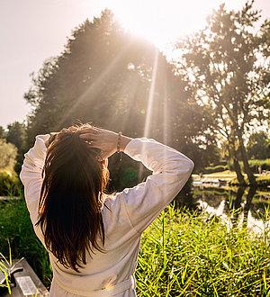 Dunkelhaarige Frau genießt den Sonnenschein im Garten