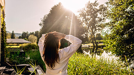Dunkelhaarige Frau genießt den Sonnenschein im Garten